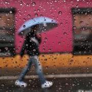 Person walking in rain with umbrella