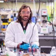 卡森布鲁斯 in a white lab coat working with tattoo equipment in his lab