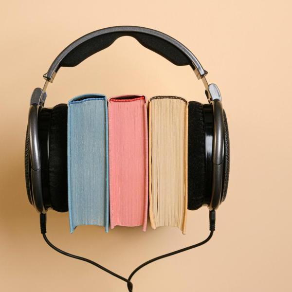 a pair of headphones sits around three books