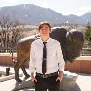 以利亚·博伊科夫在凯斯大楼屋顶. A buffalo statue is in the background with moutains in the distance.