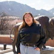 Nic Tamayo with a buffalo statue and the Flatirons in the background.