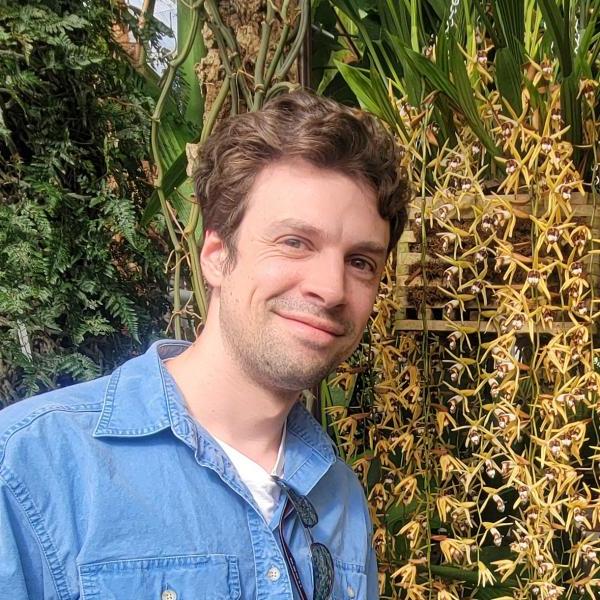 Ryan St Laurent standing next to flowering plants