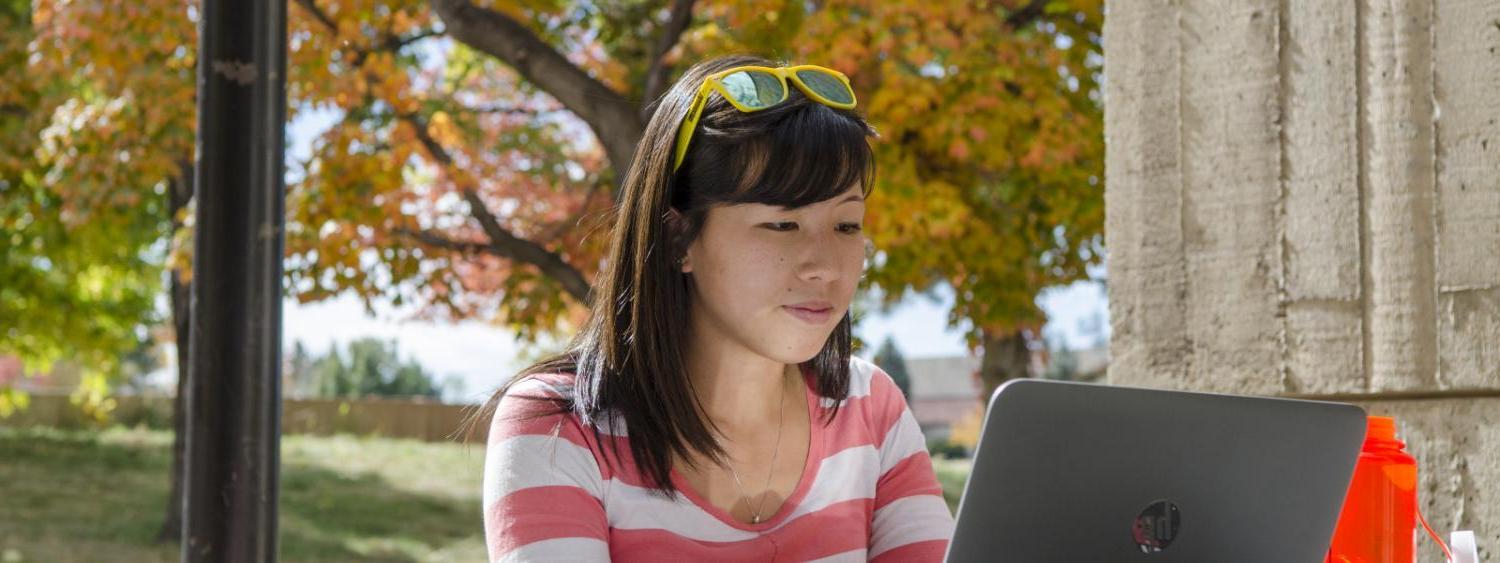 Woman sitting outside with a laptop