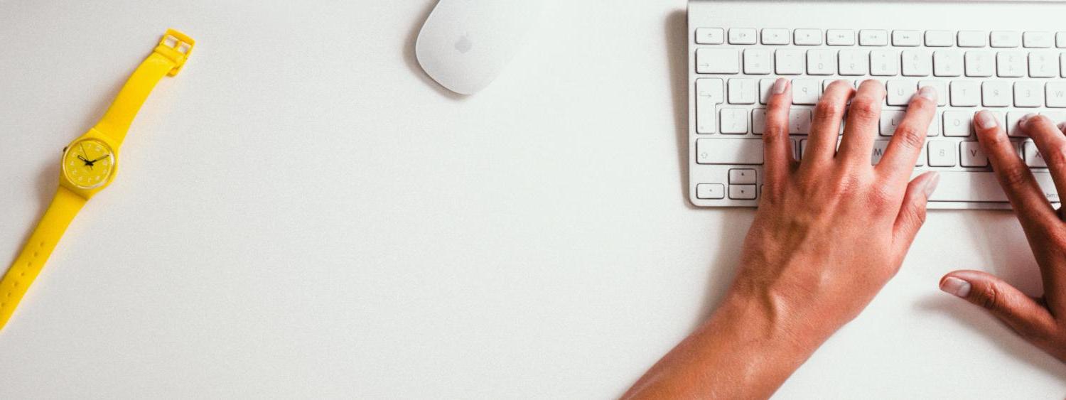 person on computer with yellow watch