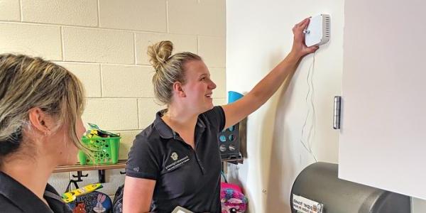  Students from Mark Hernandez’s group at the University of Colorado Boulder install an air quality monitor in a classroom. 