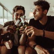 Photo of three male students playing a drinking game. 