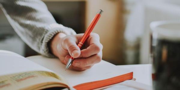 A person writing in a notebook.