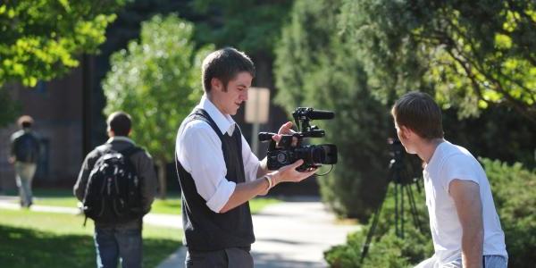 A videographer filming someone on campus