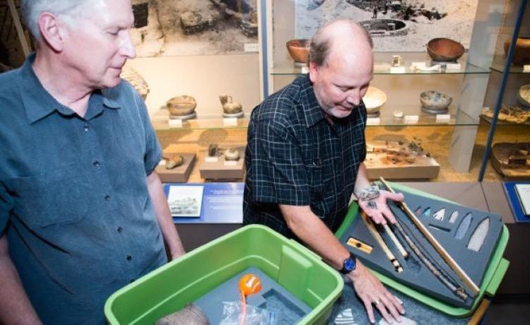 Senior museum educator Jim Hakala, left, and anthropology curator Steve Lekson prepare a fossil kit to be delivered to a Colorado classroom. 