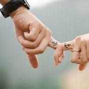 A couple holding hands with matching tattoos