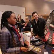 Student spins a prize wheel at The Connection booth at the spring Involvement Fair