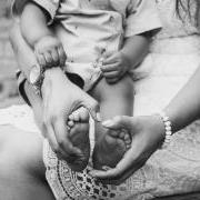 A mother holding a baby's feet