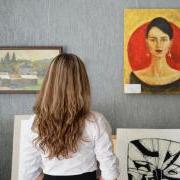 A woman looking at paintings